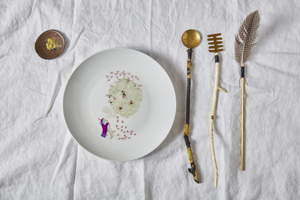 
"Species-symbolic cutlery, hand-crafted from materials foraged from a former world [...] and ceramic plates meticulously illustrated by illustrator Nicola Ferrao with mythopoetic scenes depicting the species protagonists and their narrative journeys, from destruction to resurgence." Wasp place setting, photo: Mark Cocksedge, courtesy of Superflux.