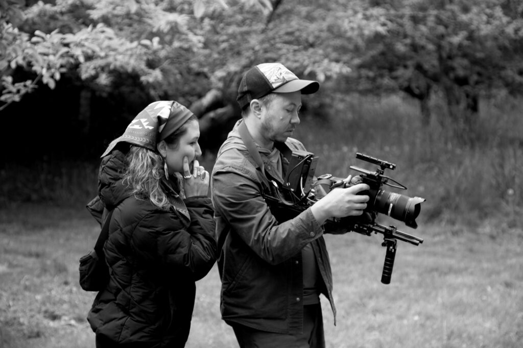 a director and a cameraman looking at the camera screen together