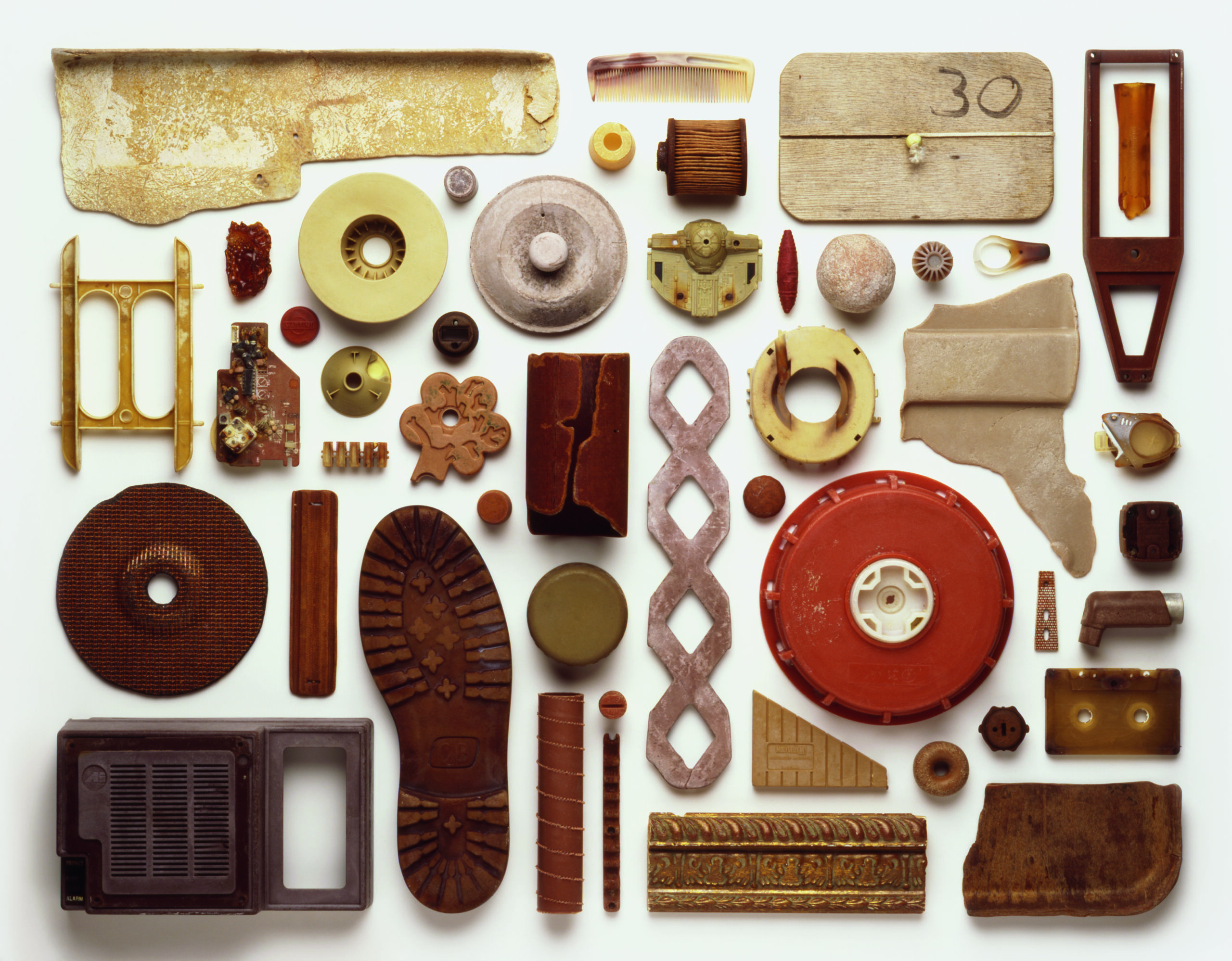 View from above of an artwork that is an arrangement of brown-coloured pieces of plastic pollution washed up on a beach in the UK