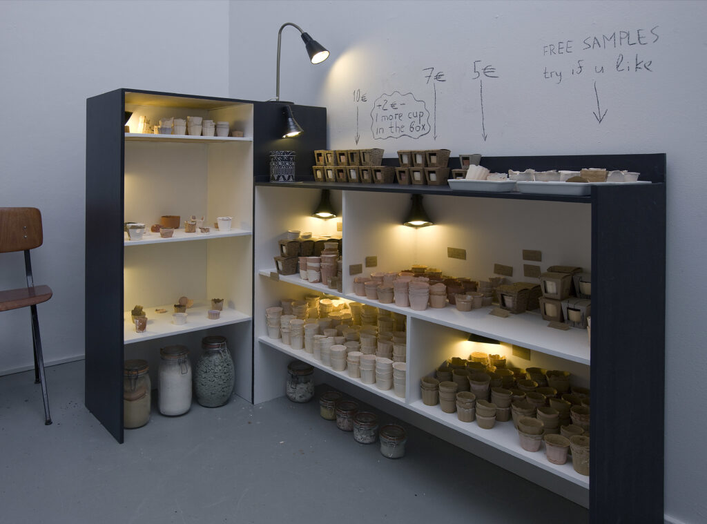 A photo of shelves in an art exhibition space holding pieces of edible ceramics.