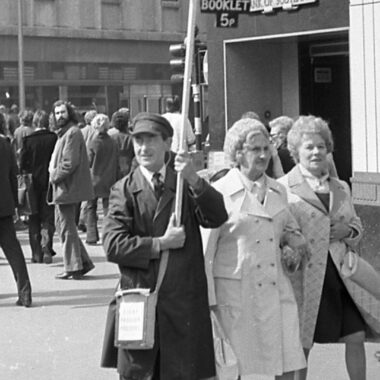 b/w photo of man walking in a street 1970s